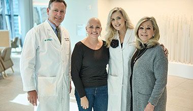 Two AHN cancer specialists posing in a photo with two patients.